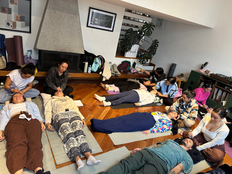 En el encuentro de Bogotá, varias mujeres recostadas sobre colchonetas reciben reflexología facial de sus compañeras